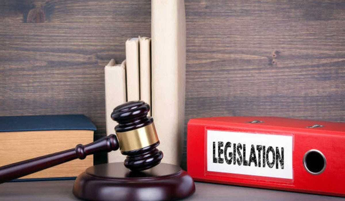 Marteau du juge posé sur un bureau à côté d'un classeur sur la législation pour illustrer l'évolution des lois au cours des années.